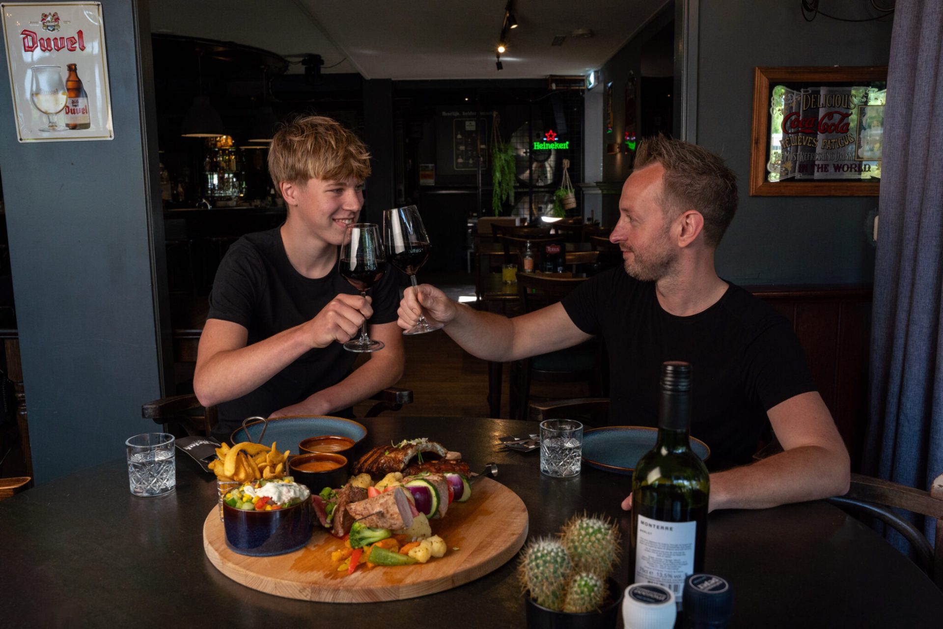 Foto van gedekte tafel met twee proostende mensen